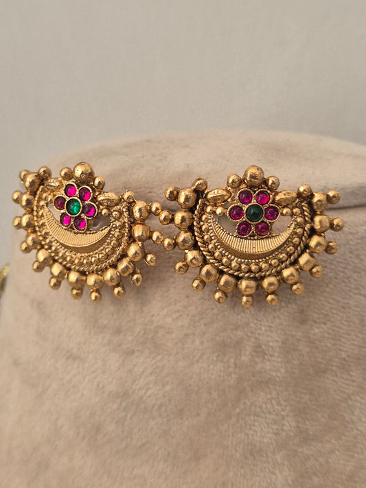 Antique gold earrings with a semicircular pendant featuring pink stone accents, and beaded trim by naitri.in