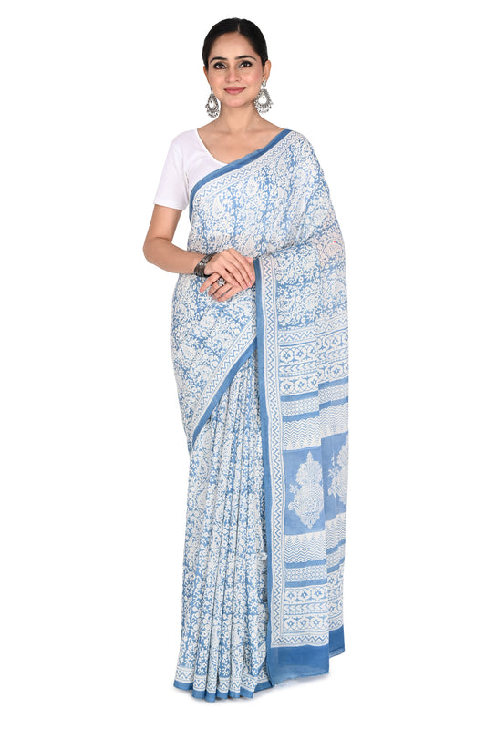 Woman wearing the Zoya hand block printed cotton saree in white and blue with a matching short-sleeved blouse by naitri.in