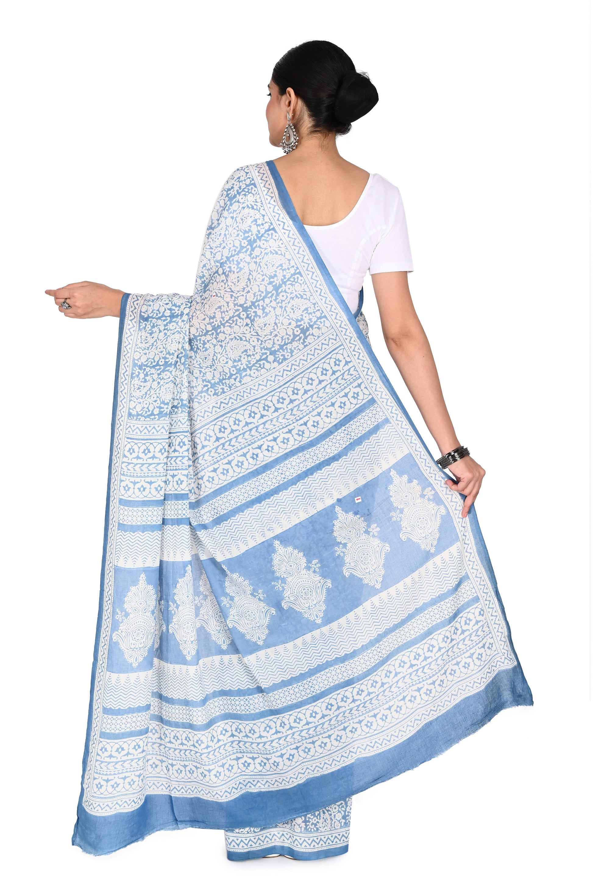 Elegant white and blue cotton saree paired with silver statement earrings, highlighting a modern Indian artisanal look by naitri.in