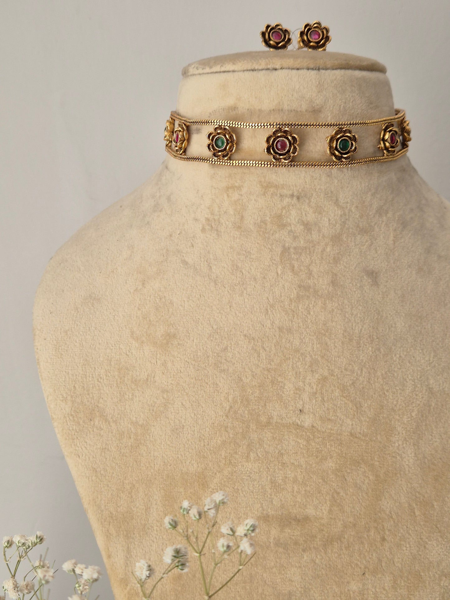 Traditional Indian-style Zuri choker with pink and green stones for a modern ethnic look gold choker and earring set with pink and green stone detailing by naitri.in