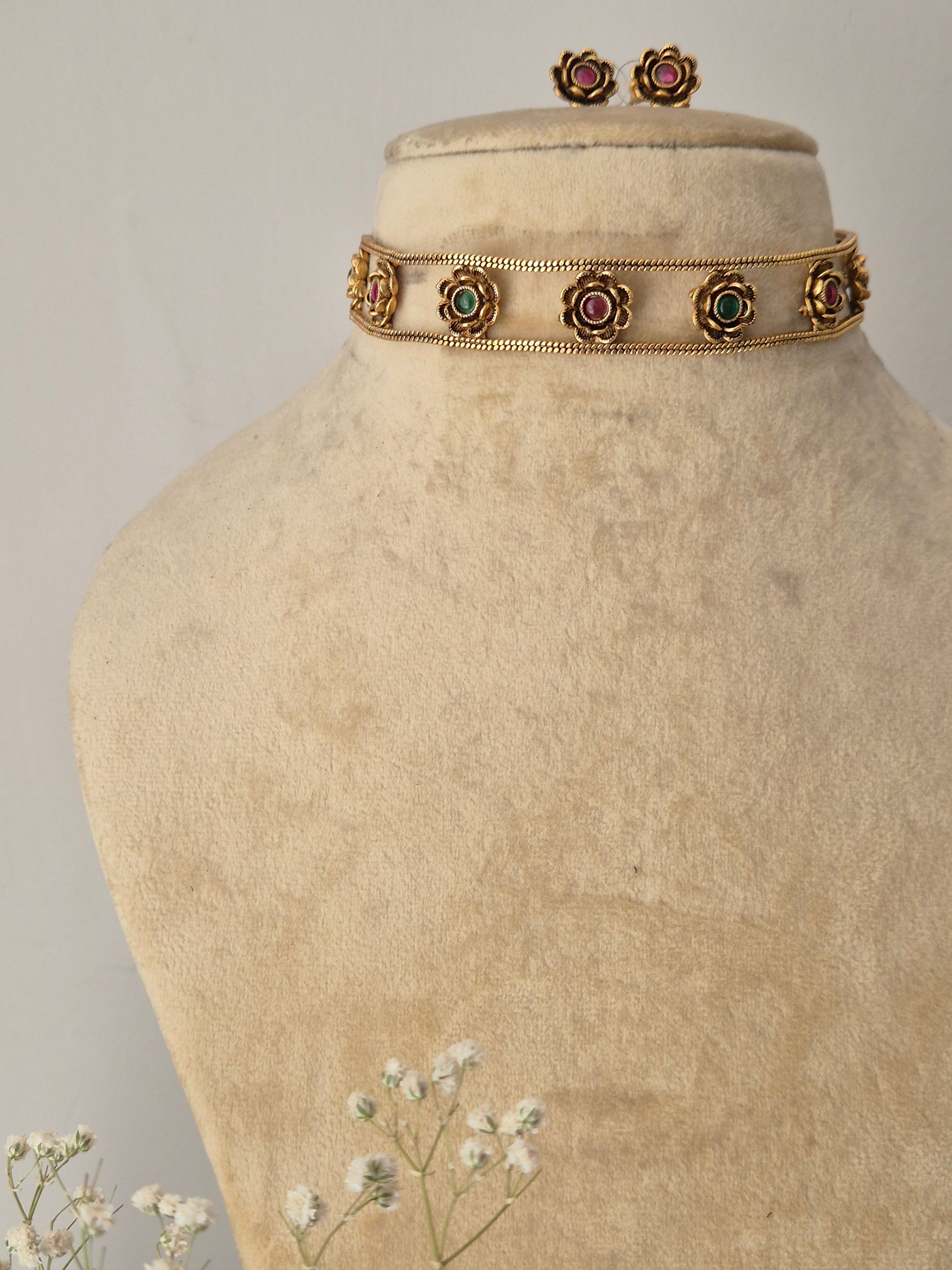 Traditional Indian-style Zuri choker with pink and green stones for a modern ethnic look gold choker and earring set with pink and green stone detailing by naitri.in